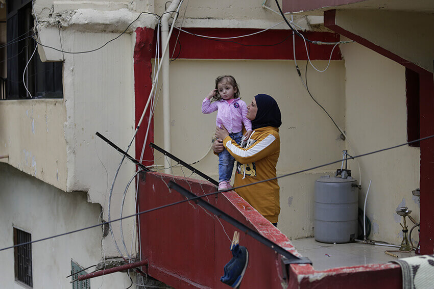 Faiqqa Homsi sostiene a su hija Maya, a quien le diagnosticaron cáncer, en el balcón de su apartamento en el barrio pobre de Mulawiya en la ciudad norteña de Trípoli, Líbano. Una crisis económica sin precedentes y las restricciones por la COVID-19 están llevando a las personas más vulnerables al límite.
