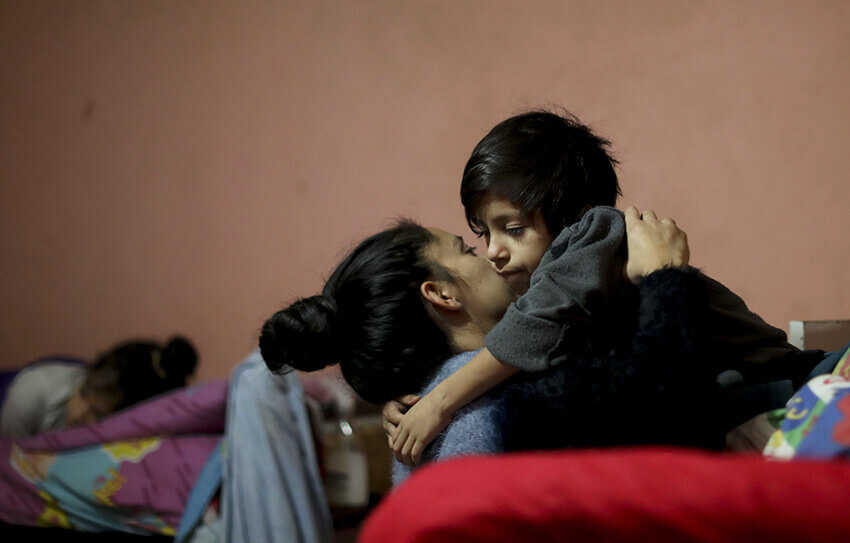 Natividad Benítez levanta a su hijo Lionel Domínguez de la cama en su casa, durante un cierre ordenado por el gobierno para frenar la propagación del nuevo coronavirus, en el barrio de chabolas Villa 1-11-14 de Buenos Aires, Argentina, el 2 de junio de 2020.