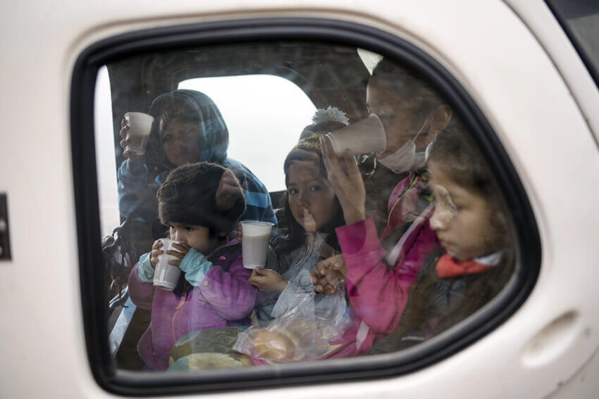 Varias niñas beben zumo de quinoa y comen pan en la parte trasera de una mototaxi en el distrito de Villa María del Triunfo de Lima, Perú, el miércoles 17 de junio de 2020. La comida fue donada por una familia adinerada y distribuida a un área de pobreza la capital en medio de la nueva pandemia de coronavirus