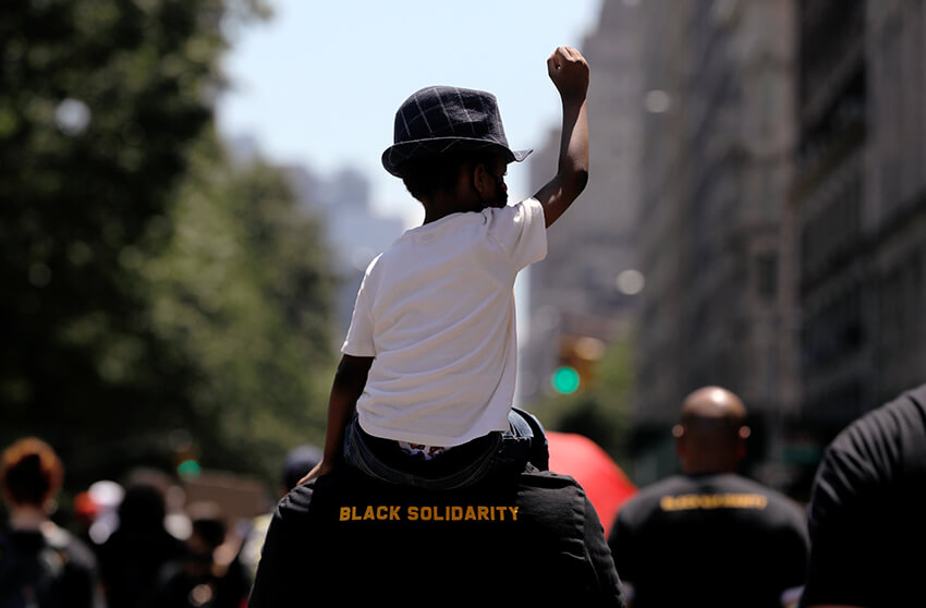 Un niño participa en un mitin mientras los manifestantes marchan por Central Park West durante los eventos para conmemorar el decimocuarto de junio, que conmemora el fin de la esclavitud en Texas, dos años después de que la Proclamación de Emancipación de 1863 liberó a los esclavos en otras partes de los Estados Unidos, en medio de protestas nacionales contra la desigualdad racial, en Nueva York, 19 de junio de 2020
